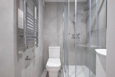 A modern bathroom featuring a spacious shower, ...