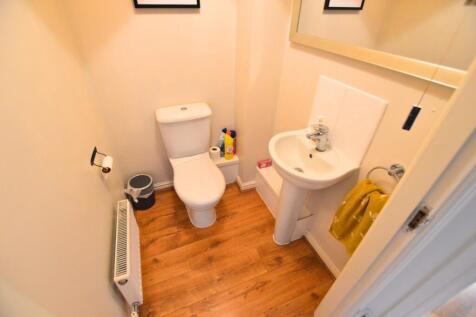 A neat and tidy toilet room featuring a white t...