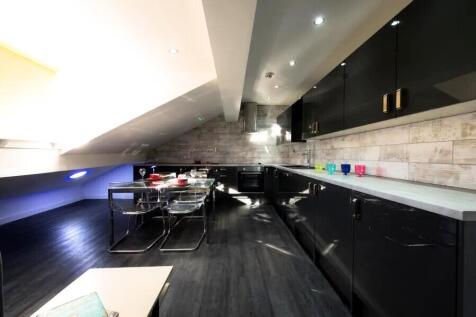 A modern kitchen with sleek black cabinets and ...