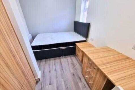 A neat and well-organized single bedroom featur...