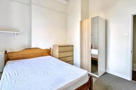 Bright and tidy double bedroom with a wooden be...