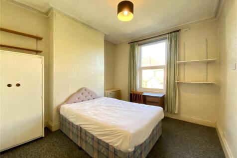 Bright double bedroom with a large window allow...