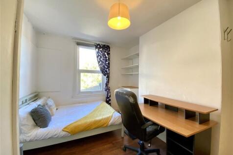 A bright and tidy single bedroom featuring a co...