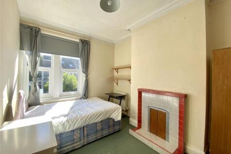 Bright single bedroom with a large window allow...