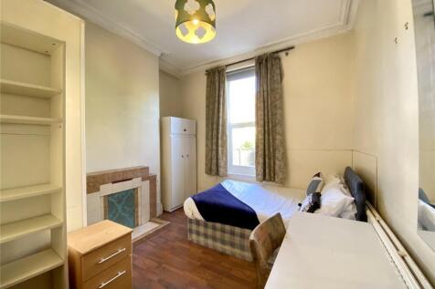 A cozy single bedroom featuring a comfortable b...