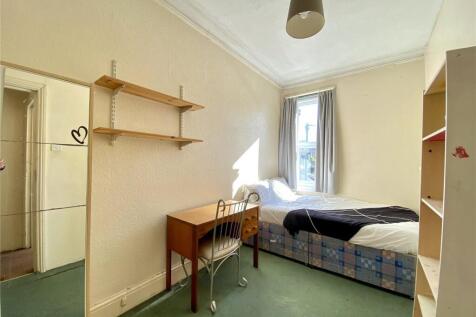 A cozy single bedroom featuring a comfortable b...