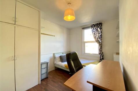 A neat and functional single bedroom featuring ...