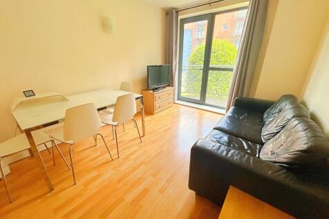 Bright living room with a sleek black leather s...