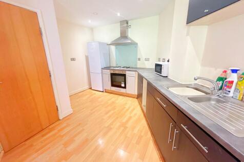 A modern kitchen featuring a sleek grey counter...