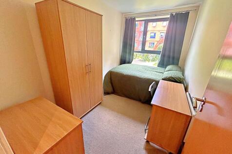 Bright single bedroom featuring a large window ...