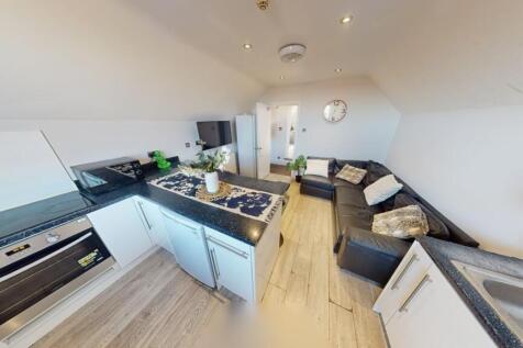 A modern, open-plan living room and kitchen are...