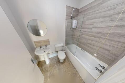 A modern bathroom featuring a bathtub with an o...