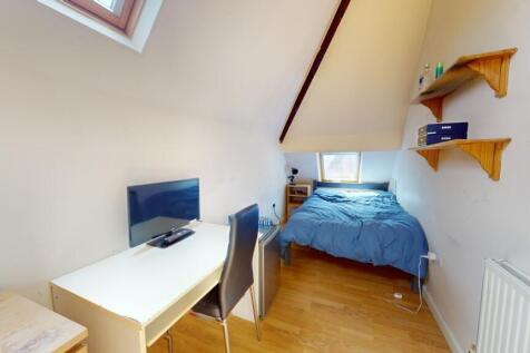 A cozy single bedroom featuring a comfortable b...
