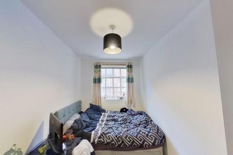 A cozy double bedroom featuring a large window ...