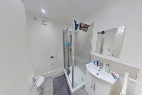 A modern and clean bathroom featuring a glass-e...