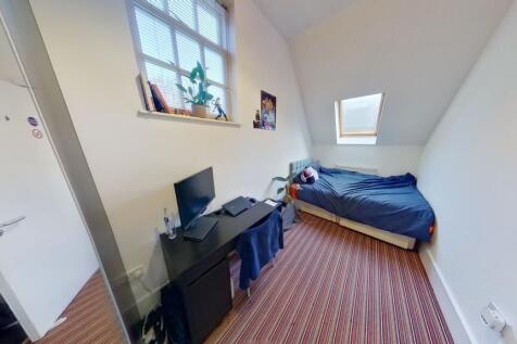 A clean and well-lit single toilet room with a ...