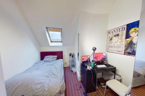 A cozy single bedroom featuring a comfortable b...