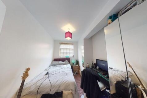 A neat and cozy bedroom with a single bed, brig...