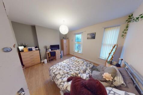 A spacious, well-lit master bedroom featuring a...
