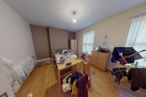 A bright double bedroom featuring wooden floori...
