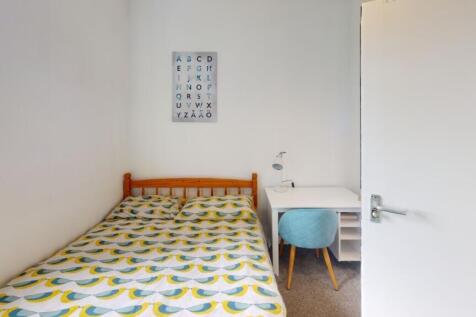 A bright and tidy single bedroom featuring a co...