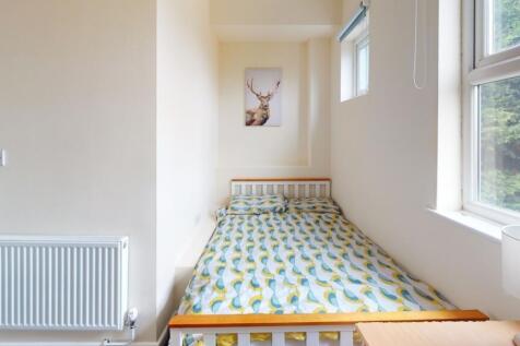 A bright and tidy single bedroom featuring a co...