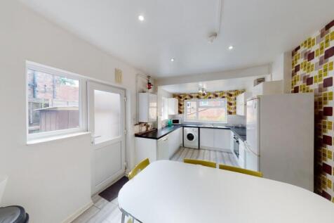 Bright and modern kitchen featuring clean white...