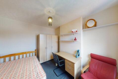 Cozy single bedroom featuring a comfortable bed...