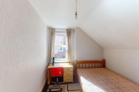 A cozy single bedroom with a wooden bed frame a...