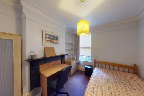Cozy single bedroom featuring a wooden bed fram...