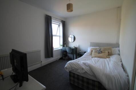 Bright and cozy master bedroom featuring a comf...
