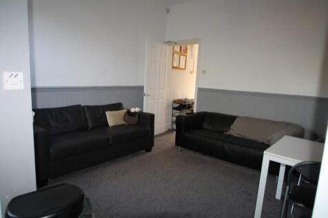 A cozy living room featuring two black sofas fa...