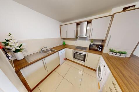 A modern and clean kitchen featuring white cabi...