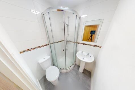 Bright and modern bathroom featuring a curved g...