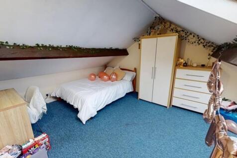 Cozy attic bedroom featuring a single bed, ward...