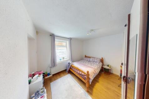 A cozy double bedroom featuring a wooden framed...
