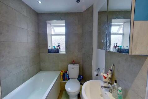 A neat and modern bathroom featuring a white ba...