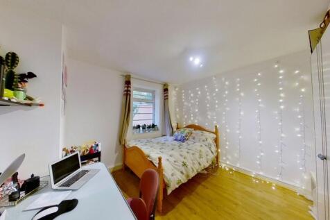 Bright and cozy single bedroom with a wooden fl...