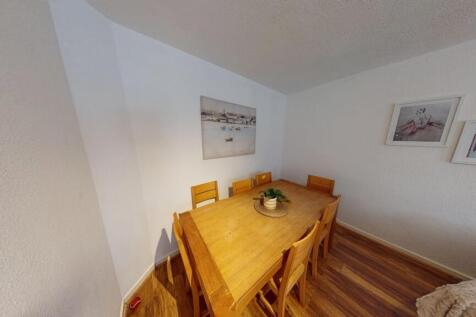 A cozy dining room with a wooden table covered ...
