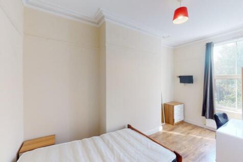 A bright double bedroom featuring a neatly made...