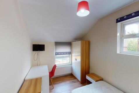 A bright and tidy single bedroom featuring a de...