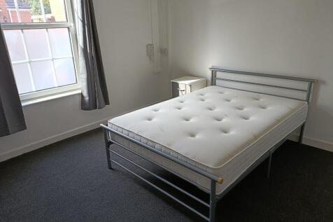 A bright double bedroom featuring a comfortable...