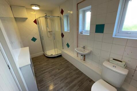 A spacious, well-lit bathroom featuring a moder...