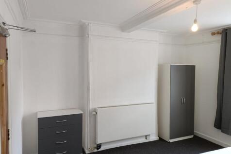 A neat and simple room featuring white walls, a...