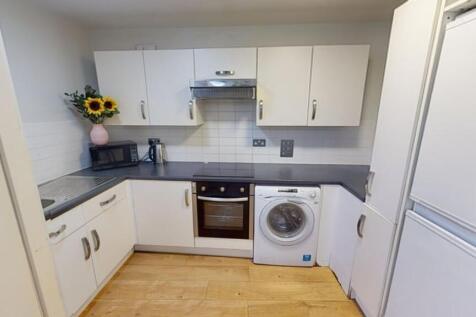 Bright and modern kitchen featuring white cabin...