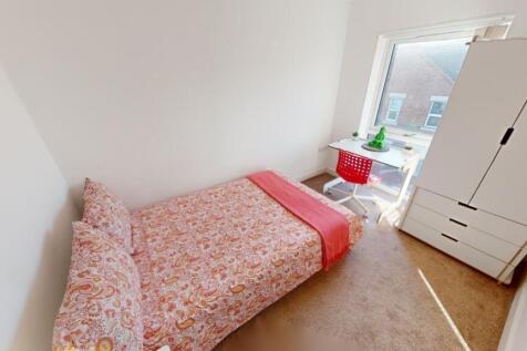 A cozy and tidy single bedroom featuring a bed ...