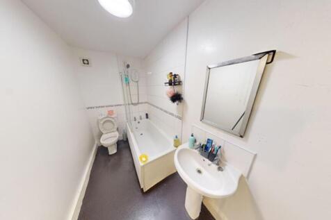A bright and tidy bathroom featuring a bathtub ...