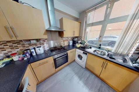 A well-lit kitchenette with ample storage and m...