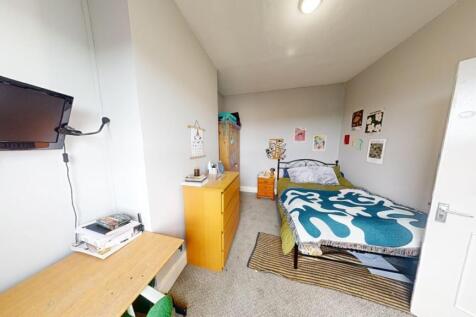 A tidy and well-lit single bedroom featuring a ...