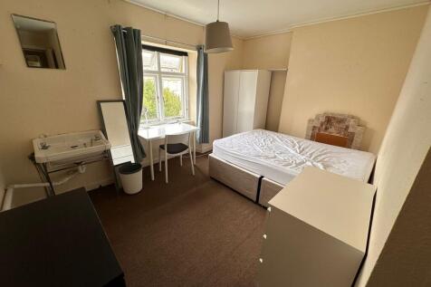 A cozy double bedroom featuring a large window ...